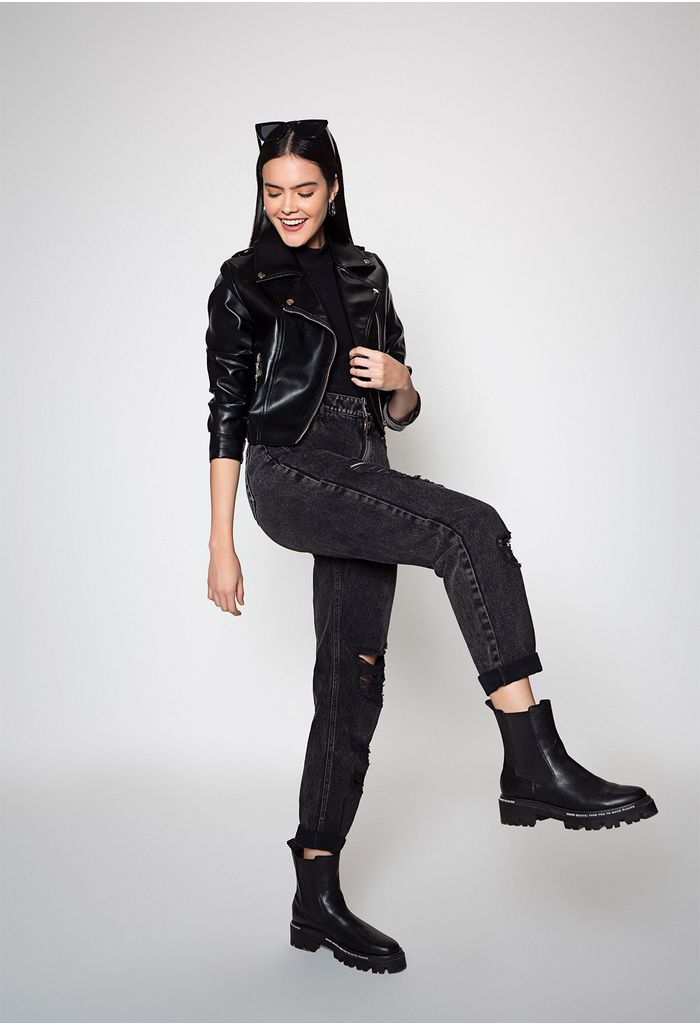 Cool moda mujer joven modelo hipster en traje de primavera de moda con  chaqueta de rock de cuero con capucha bolso negro jeans azules y zapatos de  cuero botas poses en la